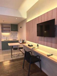a kitchen with a counter with a table and a chair at Marra Hotel in Yogyakarta