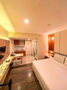 a bedroom with a large bed and a kitchen at Marra Hotel in Yogyakarta