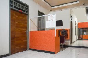 an entrance to a building with a door and a chair at Hotel O Icha Homestay in Makassar