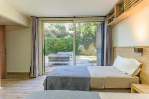 ein Schlafzimmer mit zwei Betten und einer Glasschiebetür in der Unterkunft Papiro Apart Hotel in Byblos