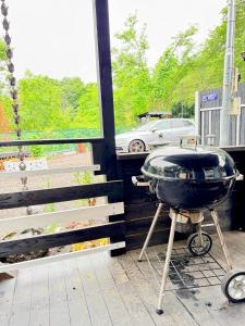 a grill sitting on a porch next to a window at Foresta Karuizawa 7 Glamping & camping for 8 people in Naganohara