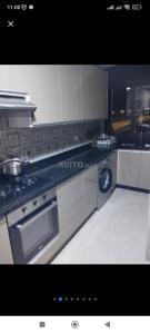 a kitchen with a stove and a dishwasher at Appartement neuf a complex colina smir in Sania Torres