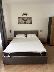 a bed in a bedroom with a white mattress at Pine Forest Apartments in Pamporovo