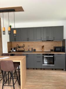 a kitchen with gray cabinets and a wooden table at Pine Forest Apartments in Pamporovo