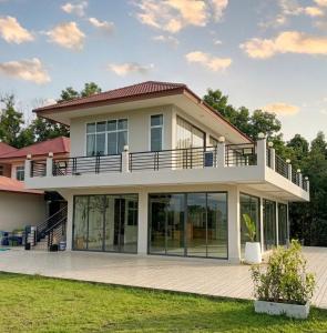 a large house with a balcony on top of it at Phuyafahsai The Resort Khao Kho in Khao Kho