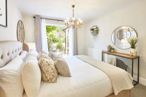 a bedroom with a large white bed with a chandelier at The Hampton Garden in Whitby