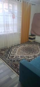 a room with a curtain and a rug and a window at Amir in Chon-Dzhargylchak