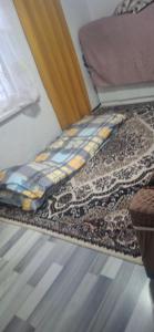 a bed in a room with a rug on the floor at Amir in Chon-Dzhargylchak