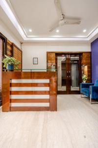 an office lobby with a reception desk and blue chairs at Royal Residence 90 in Gumgaon
