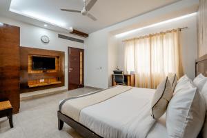a bedroom with a large bed and a television at Royal Residence 90 in Gumgaon