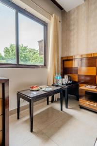 a room with a table and a large window at Royal Residence 90 in Gumgaon