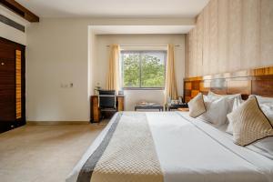 a bedroom with a large white bed and a window at Royal Residence 90 in Gumgaon +50 photos