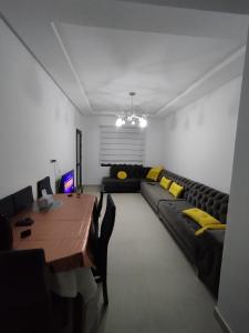 a living room with a couch and a table at Appartement neuf a complex colina smir in Sania Torres +3 photos