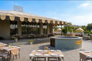 an outdoor patio with tables and a fire pit at KMR Hotels & Resorts in Bikaner