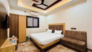 a bedroom with a bed and a couch at Hotel Viraj in Indore +44 photos