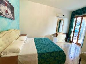 a bedroom with a bed with a green and white blanket at Hotel Costa Doro - Salve in Salve