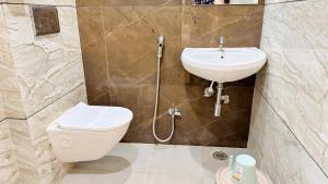a bathroom with a toilet and a sink at Hotel Viraj in Indore