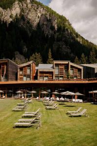 a building with a bunch of lounge chairs and a mountain at Aethos Hotel Monterosa in Champoluc