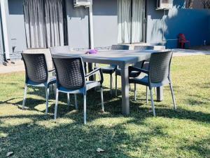 a table and chairs sitting in the grass at Vhulinganela Guest House in Ellisras