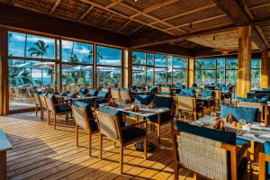 a restaurant with tables and chairs on a deck at Anaya Hotel Zanzibar in Pwani Mchangani