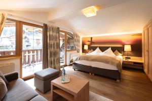 a hotel room with a bed and a couch at Olympia-Relax-Hotel Leonhard Stock in Finkenberg +80 photos