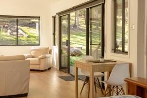 a living room with a couch and a table at Oakey Creek Retreat in Gheerulla