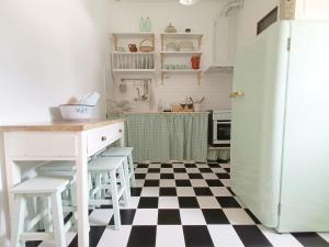a kitchen with a black and white checkered floor at Casa D'avó Souzinha in Ermidas