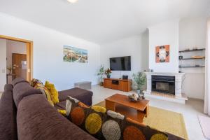 a living room with a couch and a fireplace at Casa Iguana in Budens