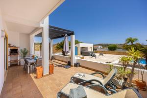 a patio with chairs and a view of the ocean at Casa Iguana in Budens