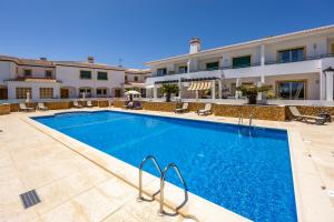 a large swimming pool in front of a building at Casa Iguana in Budens
