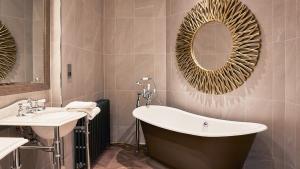 ein Badezimmer mit Badewanne, Waschbecken und Spiegel in der Unterkunft Stanbrook Abbey Hotel, Worcester in Worcester + 56 Fotos