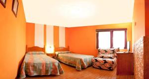 a bedroom with two beds and a chair in it at Hostal Inés in Boñar