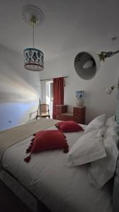 a bedroom with a large bed with red pillows at Casa D'avó Souzinha in Ermidas