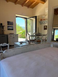 a bedroom with a bed and a large window at EtnaDetox Vineyard Open Space in Castiglione di Sicilia