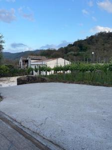 an empty parking lot with a house in the background at EtnaDetox Vineyard Open Space in Castiglione di Sicilia