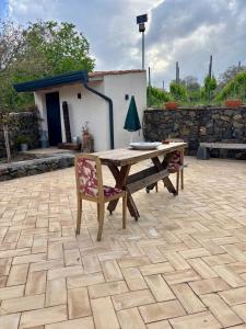 a wooden table and a chair on a patio at EtnaDetox Vineyard Open Space in Castiglione di Sicilia