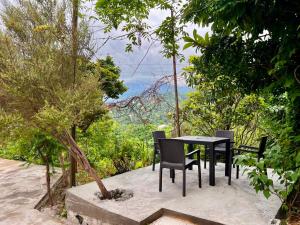 a table and chairs with a view of the forest at Botanic sea view in Batumi