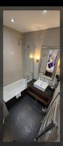 a bathroom with a tub and a sink and a mirror at Le Cocon des 2 Alpes, Spa, Jacuzzi, Piscine Chauffee in Les Deux Alpes +16 photos