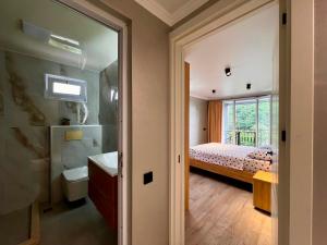 a bedroom with a bed and a bathroom with a sink at Botanic sea view in Batumi