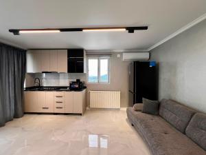 a living room with a couch and a kitchen at Botanic sea view in Batumi +9 photos