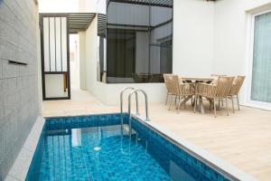 a patio with a pool and a table and chairs at Ubar-Salalah in Salalah
