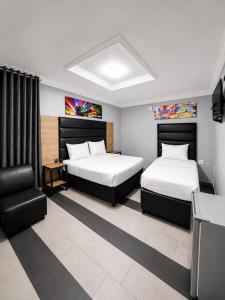 a hotel room with two beds and a chair at Metro Lodge MP in Durban
