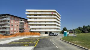 a parking lot in front of a apartment building at Apartma Tri Srca Radenci 3 sobe in Radenci