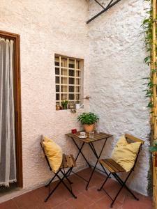 a patio with a table and chairs and a window at La Voltina in Diecimo