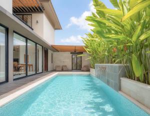 an infinity pool in the backyard of a villa at Tridi Beach Villa by Nagisa Bali in Tanah Lot