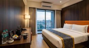 a hotel room with a bed and a large window at Royal Richmond Hotel in Dhaka