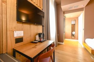 a room with a wooden table with a television on the wall at Best Western Hotel Arya in Sirmione +255 photos