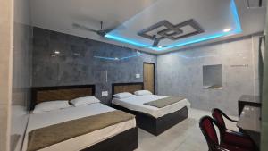 a bedroom with two beds and a table and chairs at Global Stay Mantralayam in Mādhavaram