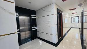 a bathroom with white marble walls and a glass door at Global Stay Mantralayam in Mādhavaram +8 photos