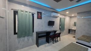 a living room with a table and a green curtain at Global Stay Mantralayam in Mādhavaram